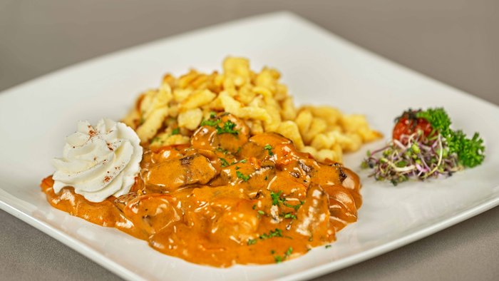 Filet Stroganof mit Spätzli und einem Weinglas